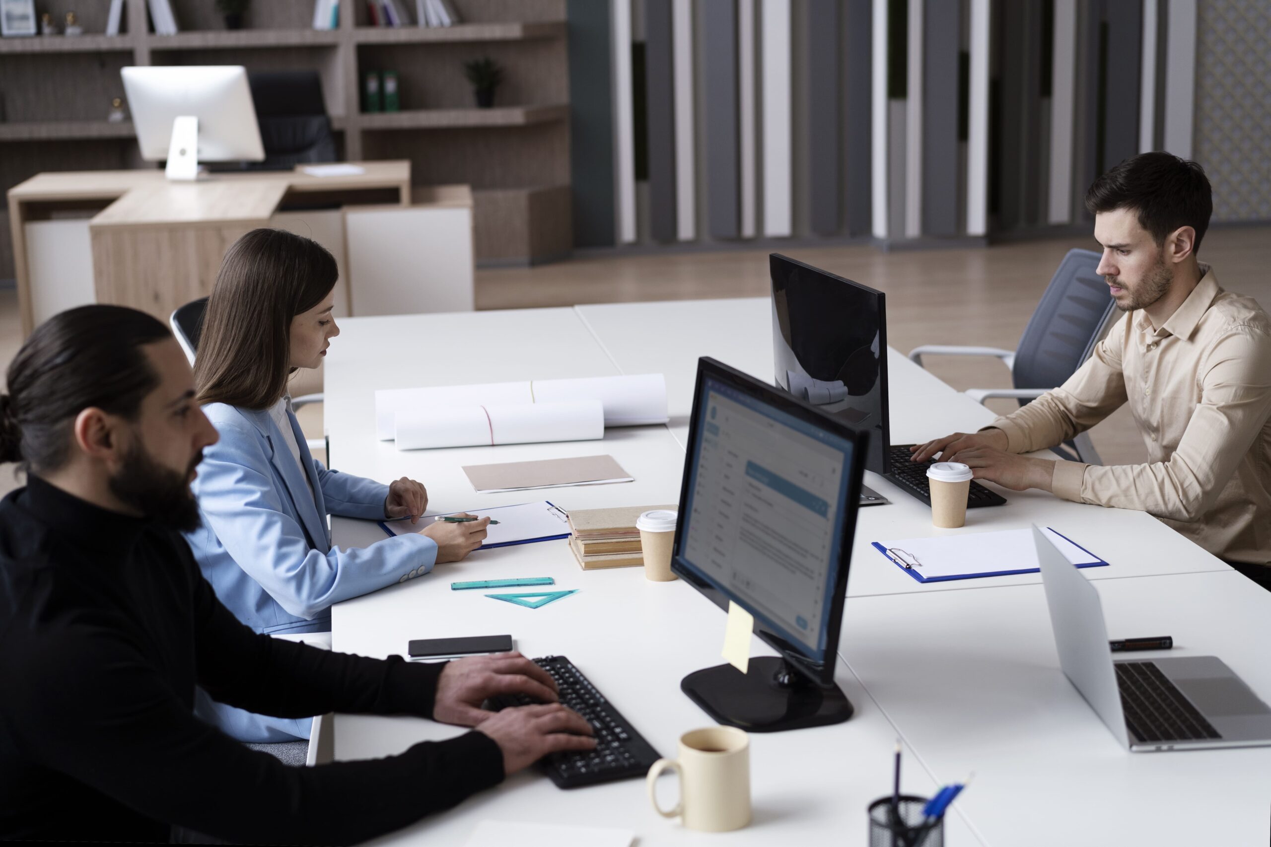 Two People Using Lapton In An Office